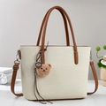 Dettaglio della borsa a secchiello in tela beige con tracolla in pelle marrone e orsetto - Bianco Sporco