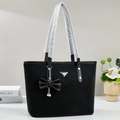 Large black woven tote bag with silver logo plaque and pearl bow charm for daily commuting - Black