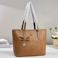 Brown woven faux leather tote bag with elegant bow charm and pearl accent detail - Earthy Yellow