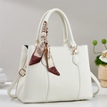 Detailed macro view of white pebble leather texture and silk scarf on tote bag handle - White
