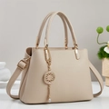 Dettaglio borsa tote beige in finta pelle con ciondolo dorato e tracolla regolabile - Cachi