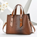 Detail of crocodile embossed tote bag with glossy dark brown texture and gold hardware - Khaki/Earth Yellow