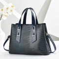 Dark blue crocodile pattern tote bag with dual handles and gold hardware on white pedestal - Blue