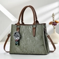 Olive green velvet tote bag with brown leather handles and a decorative pom-pom charm - Dark Green