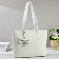 Bolso tote beige minimalista con colgante de perlas en una mesa blanca elegante - Blanco
