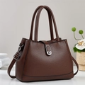 Close-up of brown lychee grain bucket bag with silver metal twist lock and dual handles - Coffee