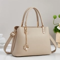 Dettaglio della borsa in pelle beige chiaro motivo litchi con catena floreale dorata - Cachi