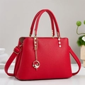 Detail of red pebbled leather handbag with golden hardware and ballerina charm - Red