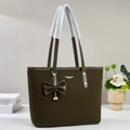 Detalle del bolso tote verde oliva con textura tejida, lazo de cuero y colgante perla - Verde