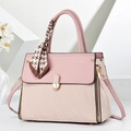 Détail d'un sac à main bicolore en simili cuir avec fermoir métallique et foulard en soie - Rose
