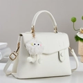 Elegant white lychee leather handbag with golden hardware and cute plush monster charm - Off White