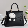 Schwarze Handtasche mit Litschi-Struktur, Plüsch-Monster-Anhänger und Schultergurt - Schwarz