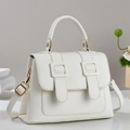 Close-up of white lychee textured crossbody bag with gold hardware and elegant handles - Off White