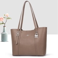 Close-up of taupe litchi grain faux leather tote bag with silver logo and pendant - Brown