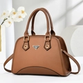 Close-up of brown pebbled leather texture and gold triangular logo on elegant handbag - Khaki/Earth Yellow