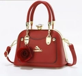 Detailed view of red shell-shaped handbag with 3D rose charm and crystal clasp closure - Red