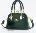 Detail of dark green leather handbag featuring golden cat logo and rose pendant - Dark Green