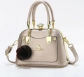 Dettaglio borsa a conchiglia metallizzata color champagne con ciondolo a rosa e cristallo - Champagne