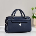 Detalle de bolso de cuero granulado azul marino con colgante plateado y costuras finas - Azul