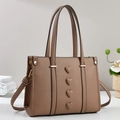 Brown textured bucket bag with 3D heart motifs and adjustable strap on a clean background - Khaki