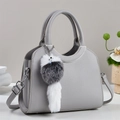 Détail du sac seau gris avec bordure métallique, cuir grainé et accessoire en peluche - Gris
