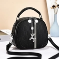 Chic black pebbled leather crossbody bag with stylish silver tassels and dog charm - Black