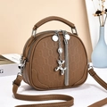 Brown shell-shaped leather crossbody bag with metal balloon dog charm and tassels - Brown