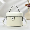 Chic cream white cylinder crossbody bag with black trim in elegant natural light - White
