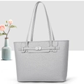Macro detail of lychee textured leather and silver oval twist lock on a tote bag - Gray