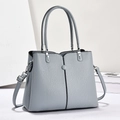 Detail der grau-blauen Handtasche mit Litschi-Struktur und silbernen Beschlägen - Hellblau