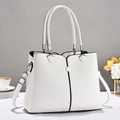 Detailed macro view of white lychee pattern leather tote with silver hardware and black trim - White