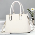 Close-up of beige crossbody bag with premium leather texture and gold hardware details - White