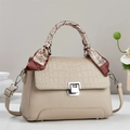 Close-up of beige leather handbag with crocodile pattern flap and silk scarf handle - Apricot
