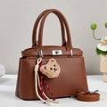 Detail of brown litchi pattern leather handbag with silver lock and bear pendant - Khaki/Earth Yellow