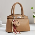 Detail of caramel leather handbag featuring lychee grain texture and cute bear charm - Dark Khaki