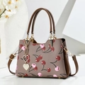 Detail of lychee pattern handbag with cherry print and heart-shaped crystal pendant - Brown