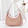 Straw hobo bag with pink leather trim and adjustable strap in studio setting - Pink