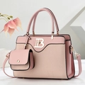 Bolso de mano rosa con diseño patchwork, logo dorado y correa sobre fondo blanco - Rosa