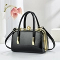 Dettaglio borsa nera texture serpente con finiture dorate e chiusura con perla grande - Nero