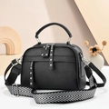 Black pebble leather crossbody bag with studded detail and geometric woven strap - Black