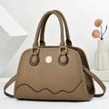 Brown lychee leather handbag with wave stitching and metal logo on a minimalist background - Brown