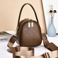 Quilted brown crossbody bag with wide strap and golden hardware in a stylish setting - Brown