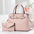 Pink crossbody handbag set with gold twist lock and matching envelope wallet on display - Pink