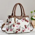 Sac fourre-tout blanc élégant avec motifs cerises et poignées en cuir marron sur table - Blanc Cassé