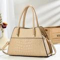 Detail of beige tote bag with crocodile pattern texture and gold-tone metal hardware - Khaki