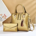 Glossy gold crocodile pattern handbag set with tassel and cat pendant on a stylish display - Gold