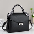 Minimalist black leather crossbody bag with lychee texture and decorative silk scarf handle - Black