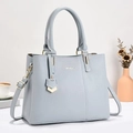 Dettaglio borsa in pelle azzurra con finiture in oro champagne e logo in metallo - Blu