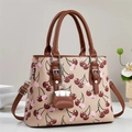 Sac à main chic en cuir beige avec imprimé cerise et mini breloque sur fond élégant - Abricot