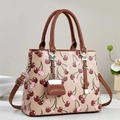 Borsa beige con stampa ciliegie e manici in pelle marrone su sfondo minimalista - Albicocca